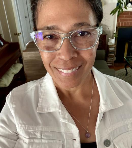 Photo of Yuuko with clear glasses, white jacket, purple pendant in cozy living room (photograph)