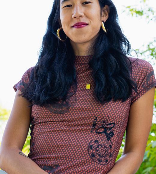 Woman with medium length black hair wearing a black and red dress smiling 
